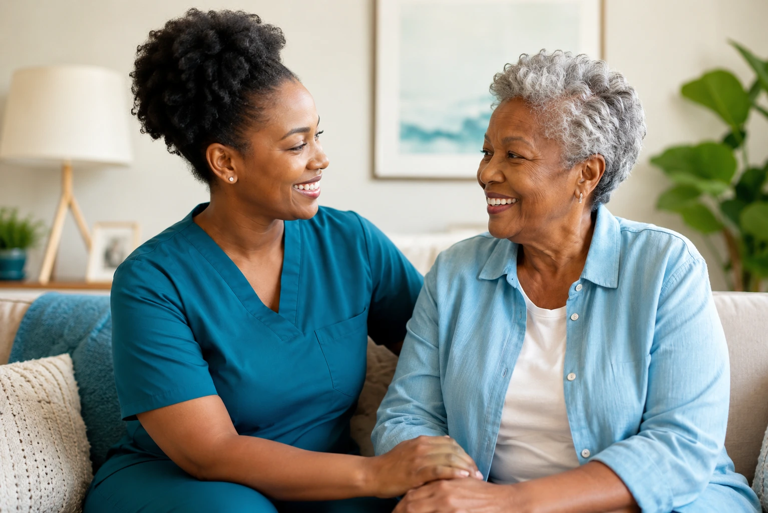 African American caregiver smiling with an elderly woman in a living room, showing companionship and supportive home care.